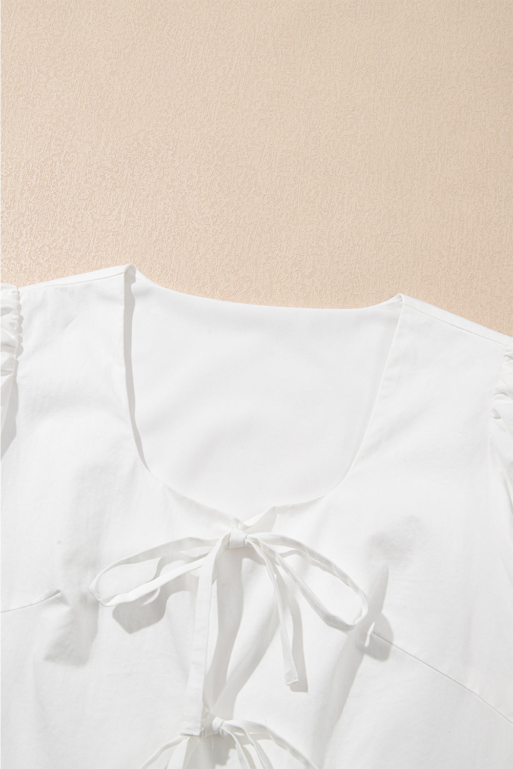 Top peplum con mangas abullonadas y lazo